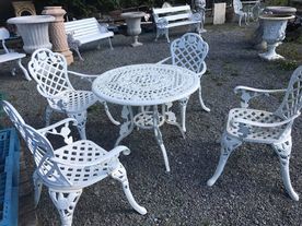 four white garden chairs surrounding a table