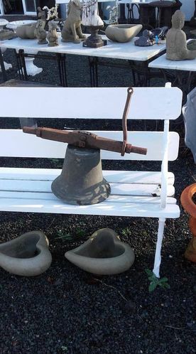 Antique bell on white garden bench